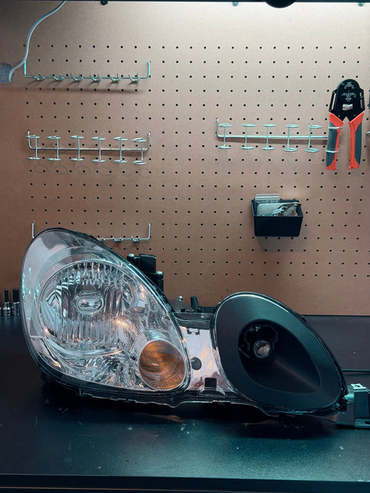 LunaticsCo MK1 Motorsport air ram with LED projector installed in a Lexus GS headlight assembly on a workbench.